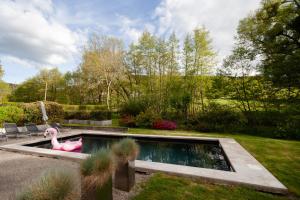 a swimming pool with a pink duck in a garden at Moulin Renaudiots - Piscine, Nature & Parc Naturel du Morvan in Autun