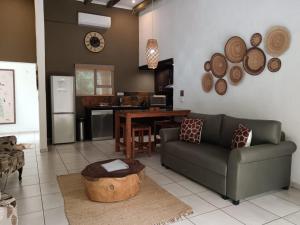 a living room with a couch and a table at Marloth Cottage in Marloth Park