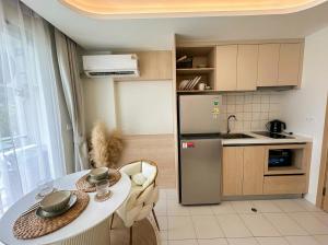 a small kitchen with a table and a refrigerator at Fantasea Condo Kamala in Kamala Beach