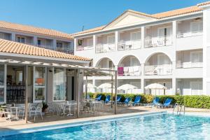 a hotel with a pool and chairs and a building at Meridien Beach Hotel in Argassi