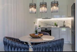 a kitchen with a table and chairs and chandeliers at Szemesbay luxus apartman in Balatonszemes