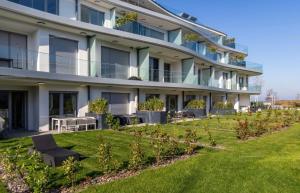 an apartment building with a lawn in front of it at Szemesbay luxus apartman in Balatonszemes