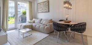 a living room with a couch and a table and chairs at Szemesbay luxus apartman in Balatonszemes