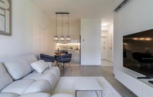 a living room with a white couch and a table at Szemesbay luxus apartman in Balatonszemes