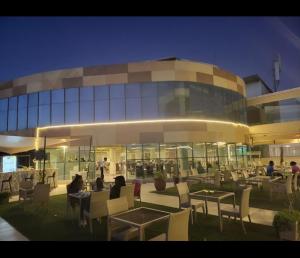 a group of people sitting at tables in front of a building at Serene 3-Bedroom House in Pridelands, Nairobi in Syokimau