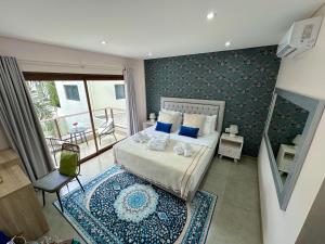 a bedroom with a large bed with a blue patterned wall at Dos Lunas Aparthotel in J. E. Estigarribia +131 photos
