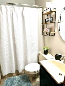 a bathroom with a white shower curtain and a toilet at Alumni Corner in State College +46 photos