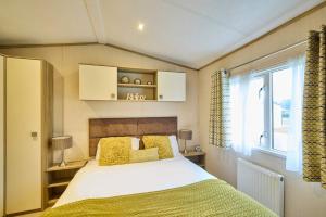 a bedroom with a large bed and a window at The Major Oak Lodge with Hot Tub in York