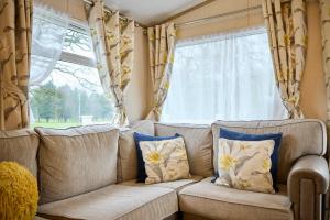 a living room with a couch and a window at The Major Oak Lodge with Hot Tub in York