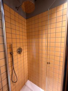 a bathroom with a shower with yellow tiles at Hotel Il Sole in Empoli +61 photos