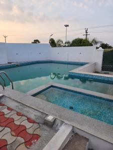 a swimming pool with blue water in a building at Bluebell castle in Mahabalipuram