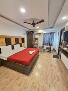 a bedroom with a large bed with a red blanket at Bluebell castle in Mahabalipuram