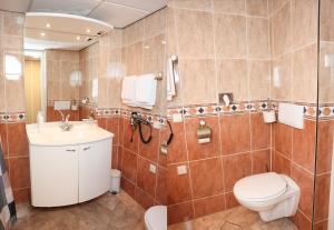 a bathroom with a toilet and a sink at Hotel Noordzee in Katwijk aan Zee +97 photos