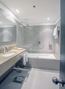 a bathroom with two sinks and a bath tub at Cité Hotel in Bogotá