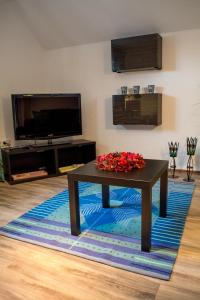 a living room with a table with flowers on a rug at Eulennest-OWL in Bad Salzuflen