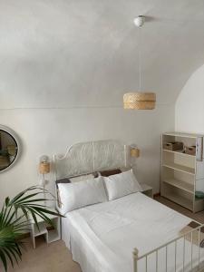 a bedroom with a white bed and a potted plant at Casa Andrée in Sanremo