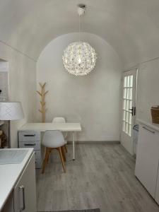 a kitchen with a white table and a chandelier at Casa Andrée in Sanremo