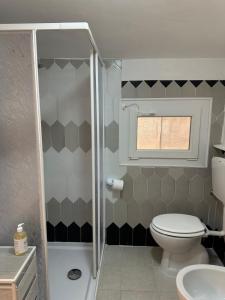 a small bathroom with a toilet and a window at Casa Andrée in Sanremo