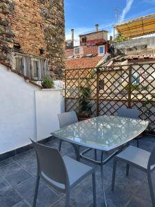 a glass table and chairs on a patio at Casa Andrée in Sanremo +13 photos