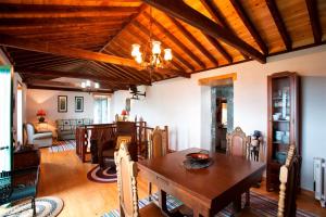 a dining room with a wooden ceiling and a table at Adegas do Pico in São Roque do Pico