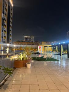 a rooftop patio at night with buildings and plants at Fifth Heaven Studio at Spectrum Mall in Noida