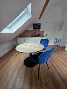 a room with a table and two blue chairs at Modern apartment in downtown in Schwäbisch Hall +2 photos