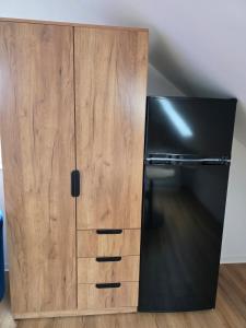 a large wooden cabinet next to a refrigerator at Modern apartment in downtown in Schwäbisch Hall