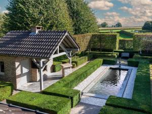 a garden with a swimming pool and a pavilion at Group accommodation in Borgloon Hof Van Kalenberg in Borgloon