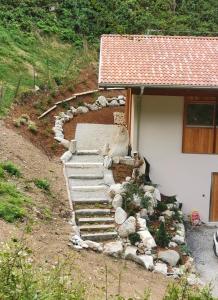 a house with a set of stairs next to a building at B&B Le Origini in Ledro