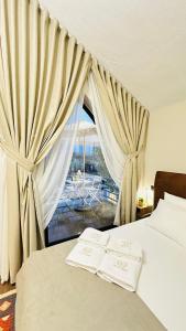 a bedroom with a bed and a window with curtains at Villa Garden Boutique Hotel Tirana in Tirana