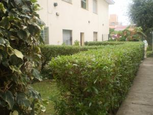 a hedge in front of a building at Departamento a media cuadra del mar Edificio"Mont Blanc" in Villa Gesell