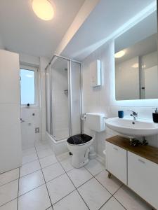 a bathroom with a toilet and a sink and a shower at FeWo Lindenallee Modern & Ruhig in Nordhorn