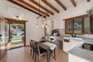 a kitchen with a table and chairs in a kitchen at La Pelusa casa rural in La Culata