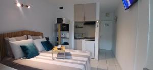 a living room with a couch and a kitchen at Le Cosy 888 Studio Plage 1 min Piscine Restaurants Casino in Les Trois-Îlets