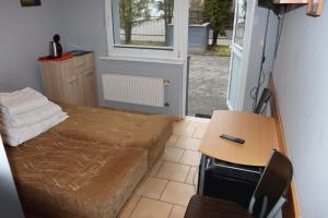 a bedroom with a bed and a desk and a table at Minuta do plaży - Sarbinowo in Sarbinowo