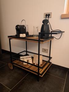a black cart with a tea kettle on it at B&B Le Origini in Ledro