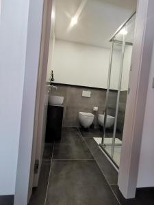 a bathroom with two toilets and a glass door at B&B Le Origini in Ledro +7 photos