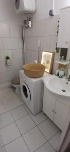 a white bathroom with a toilet and a sink at Le Cosy 888 Studio Plage 1 min Piscine Restaurants Casino in Les Trois-Îlets