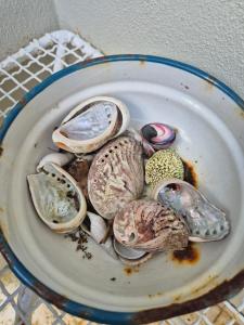 a bowl of clams and oysters on a table at Nerf-af ROOMS at Onrus , Hermanus in Hermanus