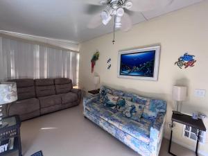 a living room with a couch and a ceiling fan at Paradise Found-Key Largo Kampground Divers Welcome in Key Largo