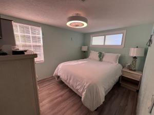 a bedroom with a white bed and two windows at Paradise Found-Key Largo Kampground Divers Welcome in Key Largo +20 photos