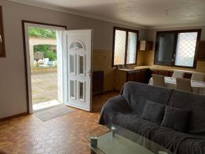 a living room with a couch and an open door at Chambre HABILIS 31 in Auterive