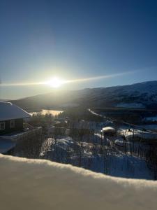 a view of the sun setting over the snow covered countryside at Central apartment in Takelvlia! in Moen