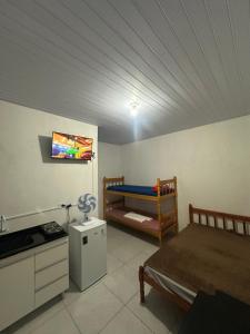 a room with two bunk beds and a kitchen at NOVO Ap Econômico em Paranaguá Completo com WiFi e Estacionamento Rotativo in Paranaguá
