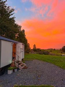 a shed with a staircase next to a sunset at Shabby Shepherds in Penrith
