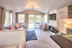 a living room with a couch and a table at Cedar Lodge With Hot Tub in Pocklington