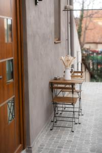 a table with a vase on it next to a building at Fly Residence 2 in Arad