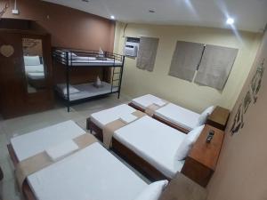 a small room with three beds and a shelf at Ciano's Hostel Cebu in Cebu City
