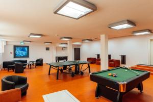 a room with two ping pong tables and chairs at Hotel Heideblick an der Lüneburger Heide in Jesteburg