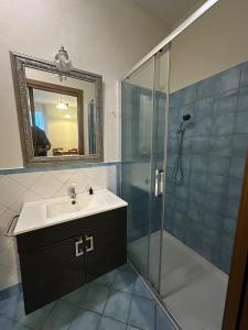 a bathroom with a sink and a shower with a mirror at Suite Cerchio 3 - City Center in Ravenna